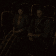 a man and a woman are sitting in a dark room with the words arthur oooh on the bottom