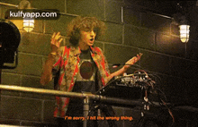 a man is standing in front of a microphone and saying i 'm sorry i hit the wrong thing .