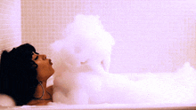 a woman is taking a bath in a bathtub filled with foam
