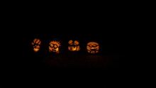 a row of carved pumpkins with different faces on them