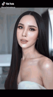 a woman with long black hair is wearing a white dress