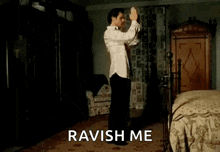 a shirtless man is dancing with a cat in a bedroom with the words ravish me behind him