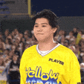 a young man wearing a yellow jersey with the word player on it