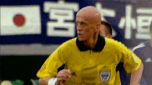 a referee wearing a yellow shirt with fifa on it