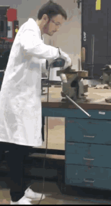 a man in a lab coat is working on a piece of metal in front of a clamp