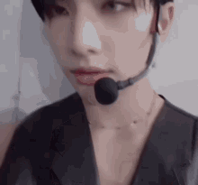 a close up of a person wearing a microphone on their neck .