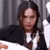 a woman is sitting on a couch looking at the camera .