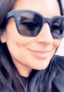 a close up of a woman 's face wearing sunglasses