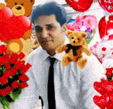 a man in a white shirt and black tie holds a teddy bear and a bouquet of red roses