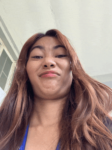 a woman with long brown hair is making a face