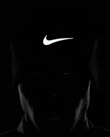a man is wearing a black nike beanie with a white swoosh on the front .