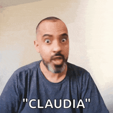 a man with a beard is making a funny face and says " claudia "
