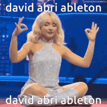a woman in a white dress is sitting in a lotus position with the words david abri ableton behind her