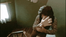a woman sitting on a staircase covering her face with her hand