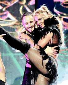 a man is holding a woman in his arms while they perform