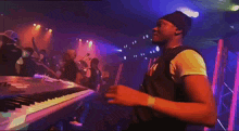 a man singing into a microphone on a stage in front of a keyboard
