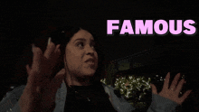 a woman is standing in the dark with the word famous above her