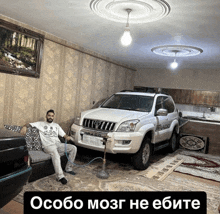 a man sits on a couch with a hookah in front of a toyota land cruiser