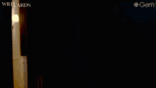 a woman in a black top is standing in a hallway with the word wildcards on the bottom