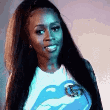 a woman with long hair is wearing a rolling stones shirt and smiling .