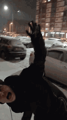 a person in a black jacket throws a snowball in the air