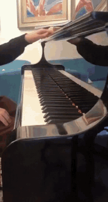 a person playing a piano with a picture of a british flag behind them