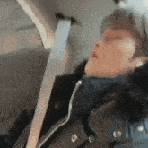 a person is sleeping in the back seat of a car .