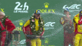 a group of men are standing on a stage with rolex advertisements behind them
