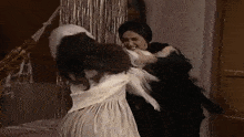 a woman in a white dress is being held by another woman in a black dress