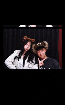a boy and a girl are posing for a picture and the boy is wearing a hat with ny on it