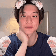 a young man with cat ears on his head and paws in front of his face