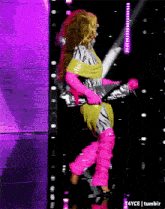 a woman in a zebra print outfit is dancing on stage