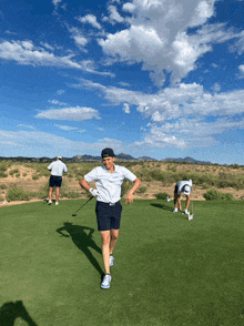 a group of people are playing golf on a lush green field