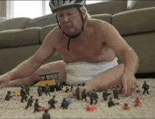 a man in a diaper is playing with toy soldiers on the floor