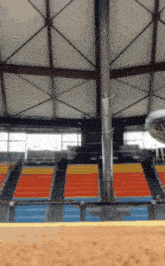 an empty stadium with rows of bleachers and a metal pole