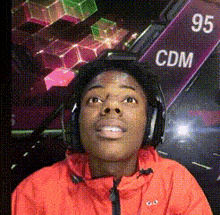 a man wearing headphones and a red jacket with the word cdm on a sign in the background