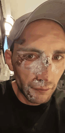 a man wearing a hat has a lot of white powder on his face