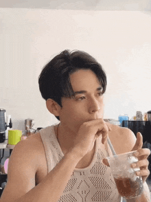 a man drinking from a plastic cup with a straw in his mouth