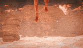 a person 's feet are hanging from a rock in a cave
