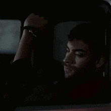a man wearing a watch is sitting in a car