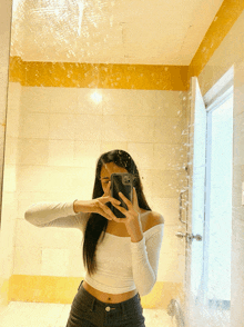 a woman taking a selfie in a bathroom mirror