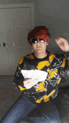 a man with red hair and sunglasses is holding a bunch of money in his hand