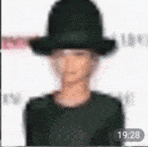 a blurry picture of a person wearing a hat with the time 19:28 on the bottom