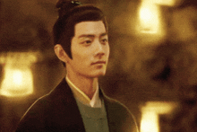 a man with a bun on his head is looking at the camera