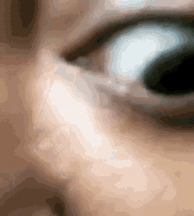 a close up of a person 's eye with a very blurry background .