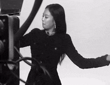 a black and white photo of a woman in a black dress