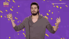 a man with a beard is standing in front of a purple background with the words multi show on it .
