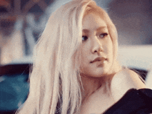 a close up of a woman with blonde hair wearing a black top