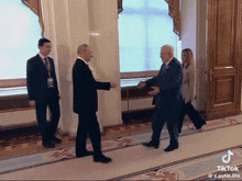 a man in a suit shakes hands with another man