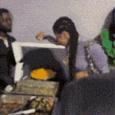a man and a woman are sitting at a table with food . the woman is wearing a purple top .
